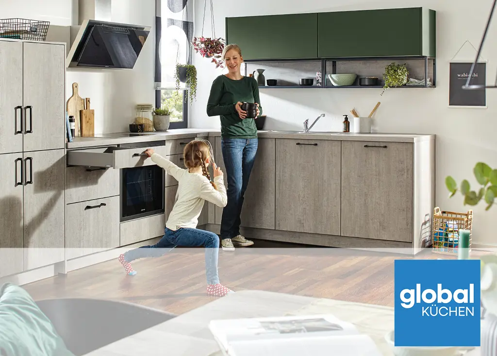 Familienküche von Global Küchen mit grauen Fronten und grünen Oberschränken. Mutter und Kind in einer offenen Wohnküche mit Backofen, Auszügen und viel Arbeitsfläche für den Alltag moderner Familien.